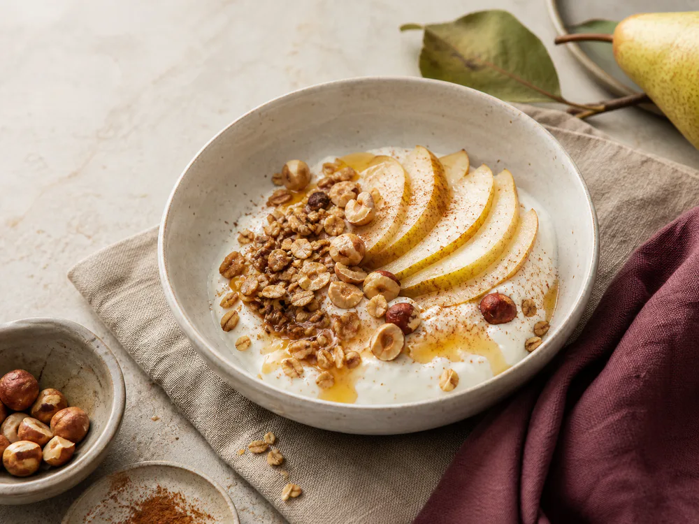 Bol de yaourt, poire, granola et noisettes